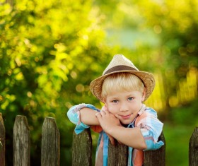 The little boy standing next to the fence Stock Photo