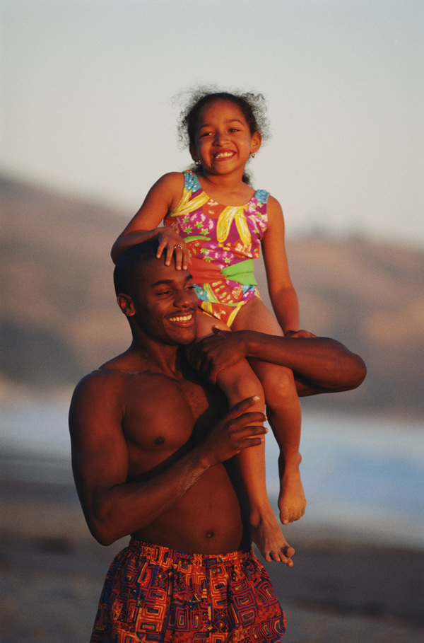 The little girl sitting on my fathers shoulder Stock Photo