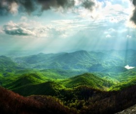 The sunlight penetrated the black clouds round the mountains Stock Photo