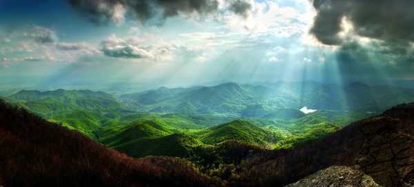 The sunlight penetrated the black clouds round the mountains Stock Photo