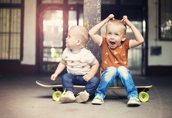 The two little boys sitting on the skateboard Stock Photo