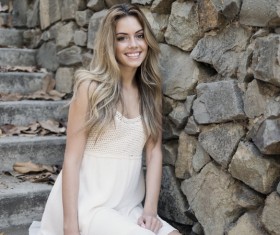 The woman sitting on the stone steps smiling Stock Photo