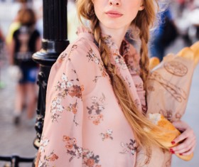 The young girl holding the bread on the street Stock Photo 01