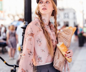 The young girl holding the bread on the street Stock Photo 02