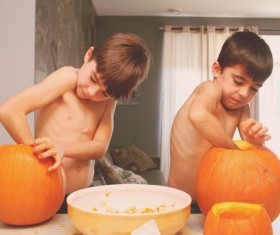 Two little boy digging pumpkin seeds Stock Photo
