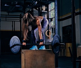 Woman in the gym lifting barbell Stock Photo 05
