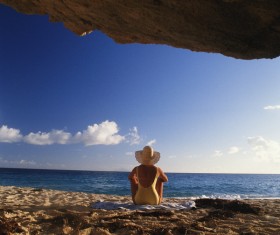 Woman sitting on the beach back shadow Stock Photo