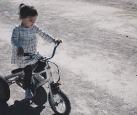 little girl practising riding bicycle Stock Photo