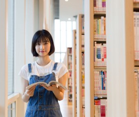 Girl reading a book in the library Stock Photo