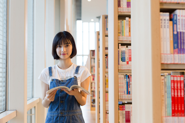 Girl reading a book in the library Stock Photo