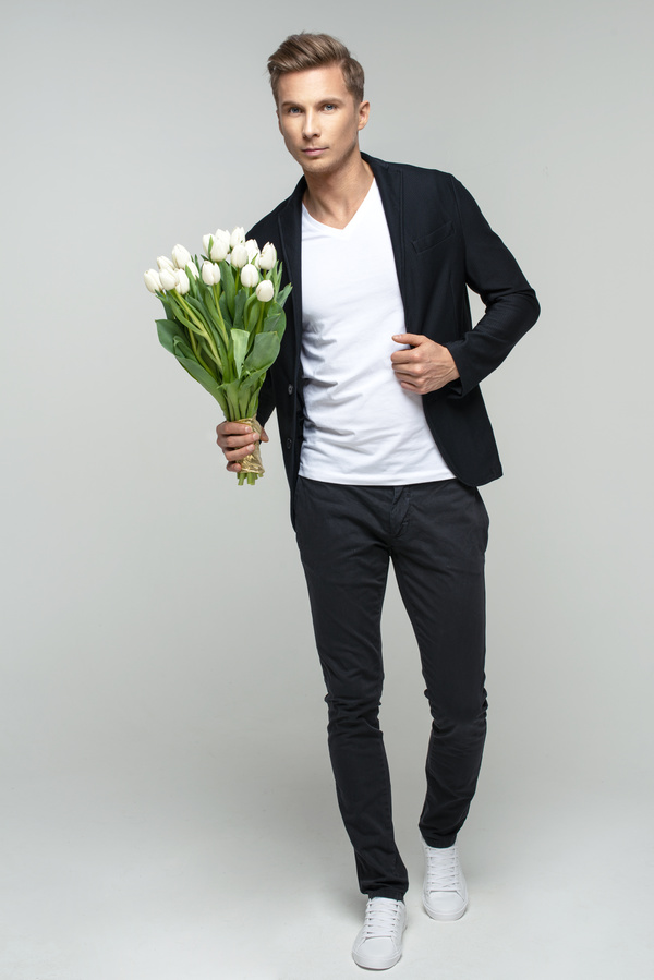 Handsome young male holding flowers Stock Photo