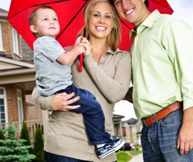 Holding the child with an umbrella mother and father Stock Photo