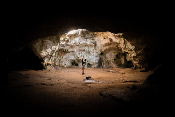 Lonely woman in stone cave Stock Photo
