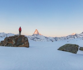 Man standing on rocky snow mountain Stock Photo