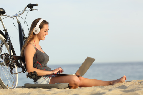 Online chat on the beach happy woman Stock Photo