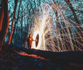 Person with sparkling fireworks in forest Stock Photo