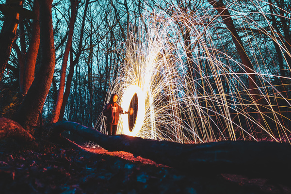 Person with sparkling fireworks in forest Stock Photo