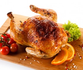 Roasted whole chicken with tomatoes on the chopping block Stock Photo