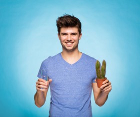 Smiling man ready to water the cactus Stock Photo