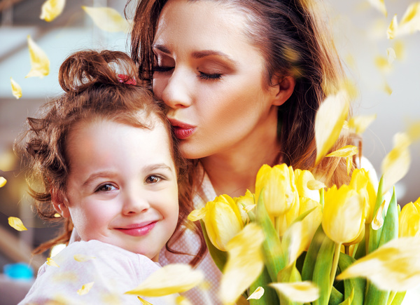 Smiling mother kissing daughter Stock Photo