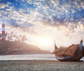 The lighthouse on the island and the boat on the beach Stock Photo