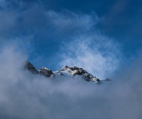 Thick cloud covering snowy peak Stock Photo