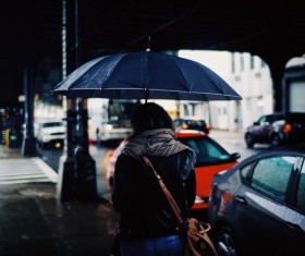 Woman walking under rainy weather with umbrella Stock Phot