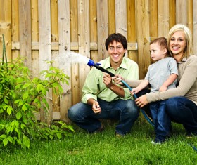 Young couples with children to water the plants Stock Photo