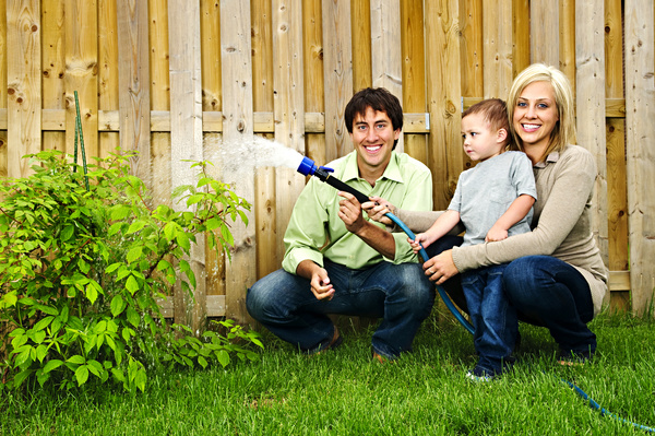 Young couples with children to water the plants Stock Photo