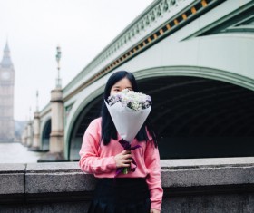 Young girl posing with flowers in classical city Stock Photo
