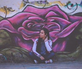 Young woman posing by artistic painted wall Stock Photo