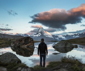 man standing on quiet mountain lake landscape Stock Photo