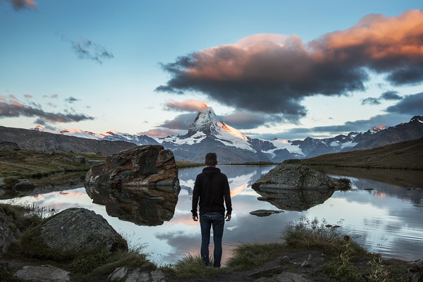man standing on quiet mountain lake landscape Stock Photo