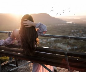 Back view of girl sitting on bench Stock Photo