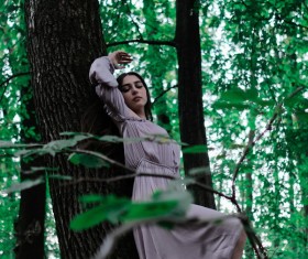 Beautiful girl relying on the big tree Stock Photo
