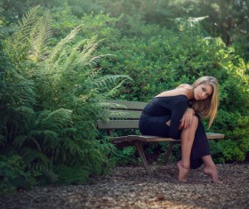 Beautiful girl sitting on a bench outdoors Stock Photo