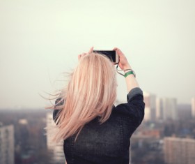 Blonde girl taking picture of the cityscape Stock Photo