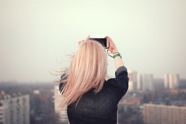 Blonde girl taking picture of the cityscape Stock Photo