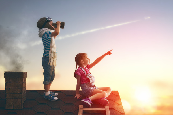 Children on the roof looking at planes Stock Photo