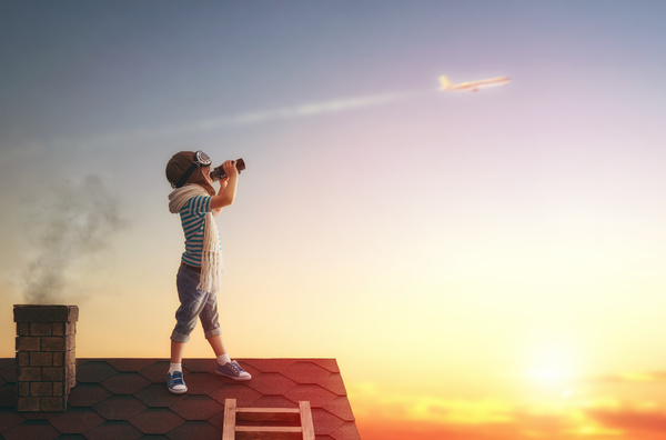 Children on the roof with a telescope to see the plane Stock Photo