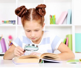 Children reading books with magnifying glass Stock Photo