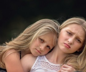 Cuddling sisters Stock Photo