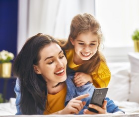 Daughter looked at the mother smartphone Stock Photo