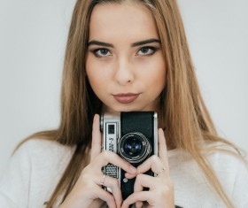 Girl holding camera in hand Stock Photo