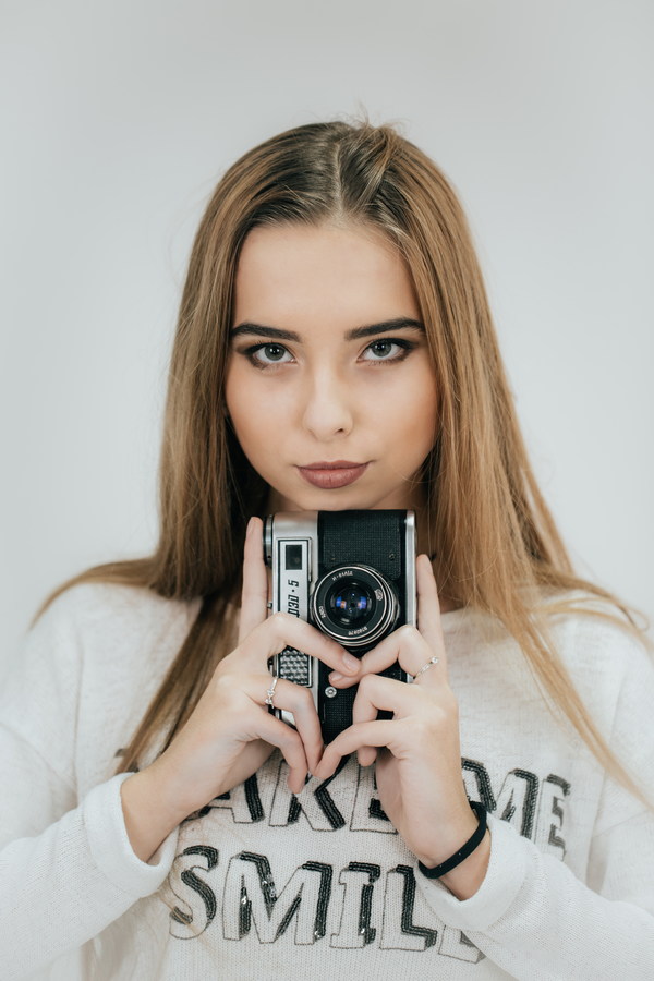 Girl holding camera in hand Stock Photo