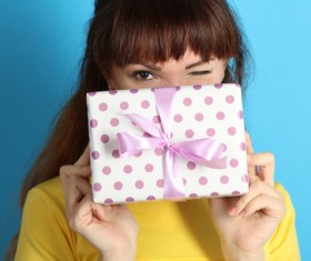 Grimacing woman holding a gift box Stock Photo