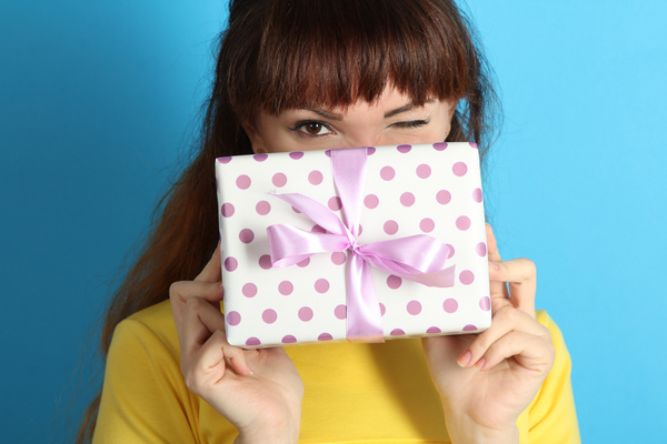 Grimacing woman holding a gift box Stock Photo