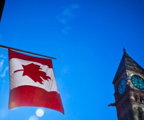 Hanging Canadian flag and clock tower Stock Photo