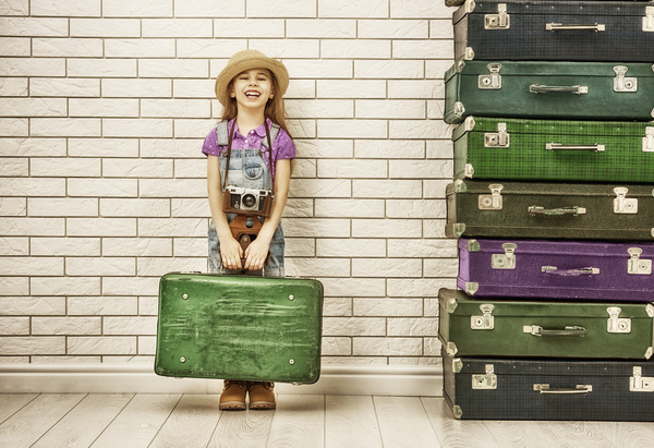 Happy little girl holding a suitcase Stock Photo