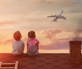 Little brother and sister sitting on the roof Stock Photo